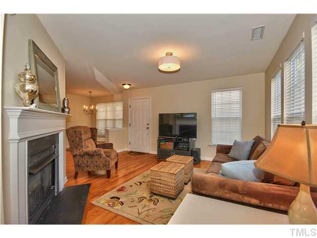 9827 Layla Avenue Raleigh, NC 27617 - Photo 3 of 20 a living room with furniture a fireplace and a flat screen tv