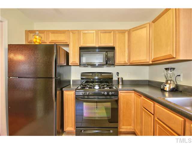 9827 Layla Avenue Raleigh, NC 27617 - Photo 7 of 20 a kitchen with granite countertop a refrigerator stove top oven and sink