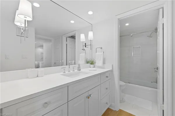 a bathroom with a sink double vanity granite tub and shower