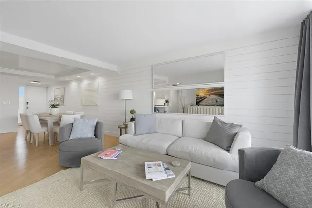 a living room with furniture and a view of kitchen