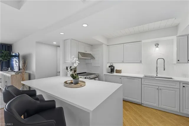 a kitchen with kitchen island white cabinets a table and chairs