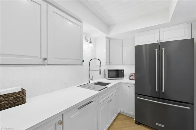 a kitchen with appliances a sink and cabinets