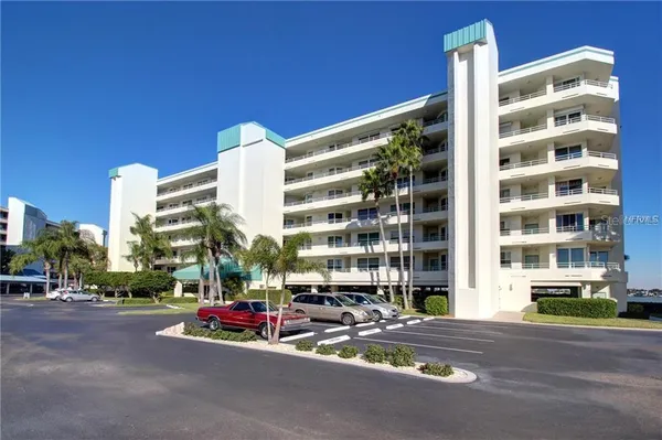 a view of building with cars parked across