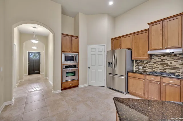 a kitchen with stainless steel appliances granite countertop a refrigerator and a sink