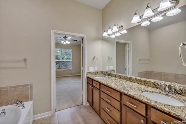 a bathroom with a granite countertop sink a large mirror and a shower