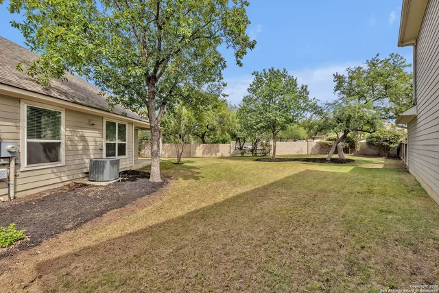 a view of a house with backyard and trees
