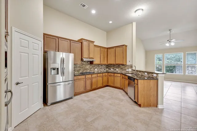 a kitchen with stainless steel appliances granite countertop a refrigerator sink and cabinets