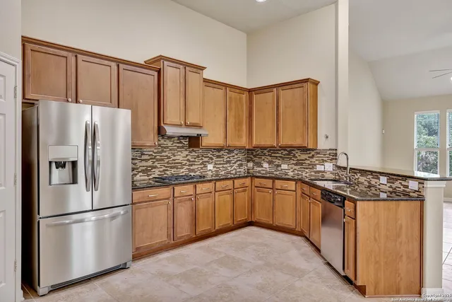 a kitchen with stainless steel appliances granite countertop a refrigerator sink and cabinets