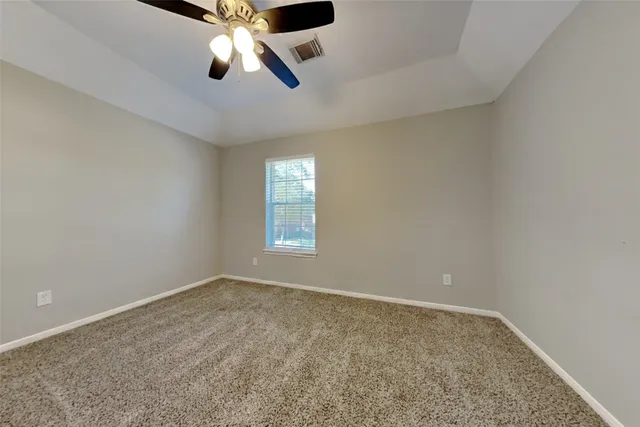 an empty room with a window and a ceiling fan