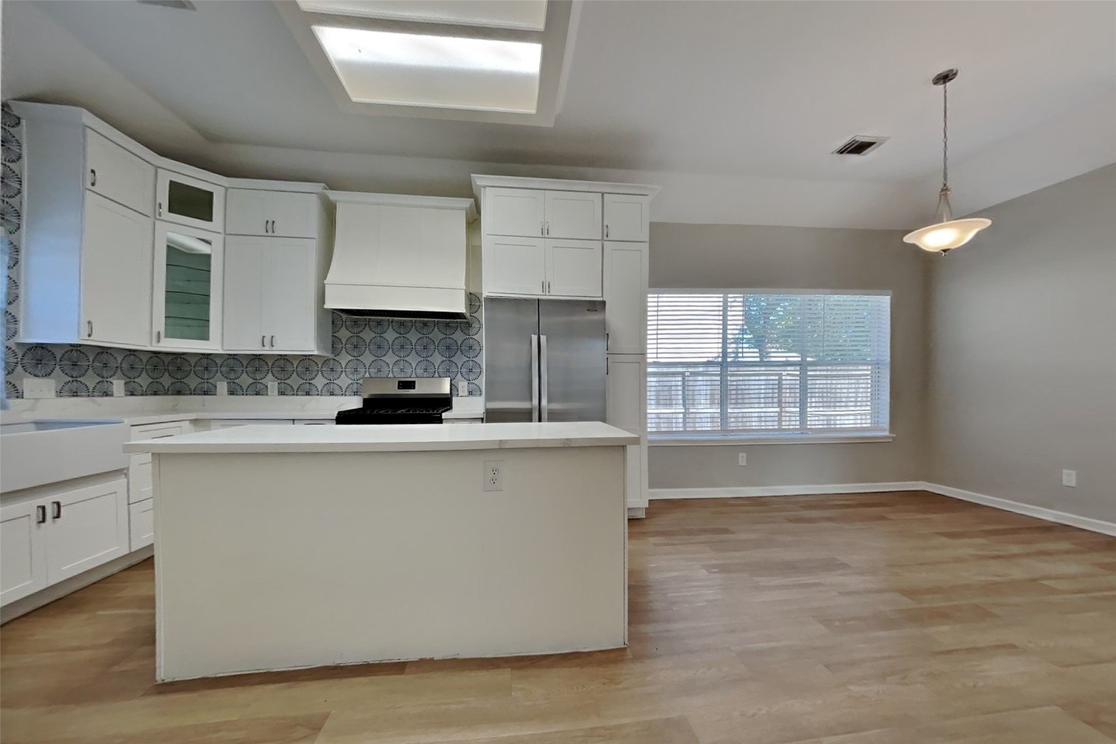 30110 Granum Drive Spring, TX 77386 - Photo 7 of 22 a large kitchen with granite countertop a stove a sink a refrigerator and white cabinets with wooden floor