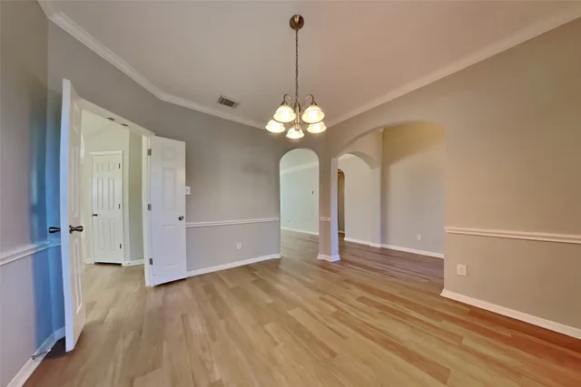 a view of a chandelier in big room with wooden floor