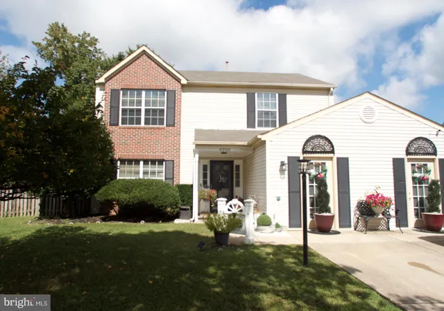 a front view of a house with a garden and plants