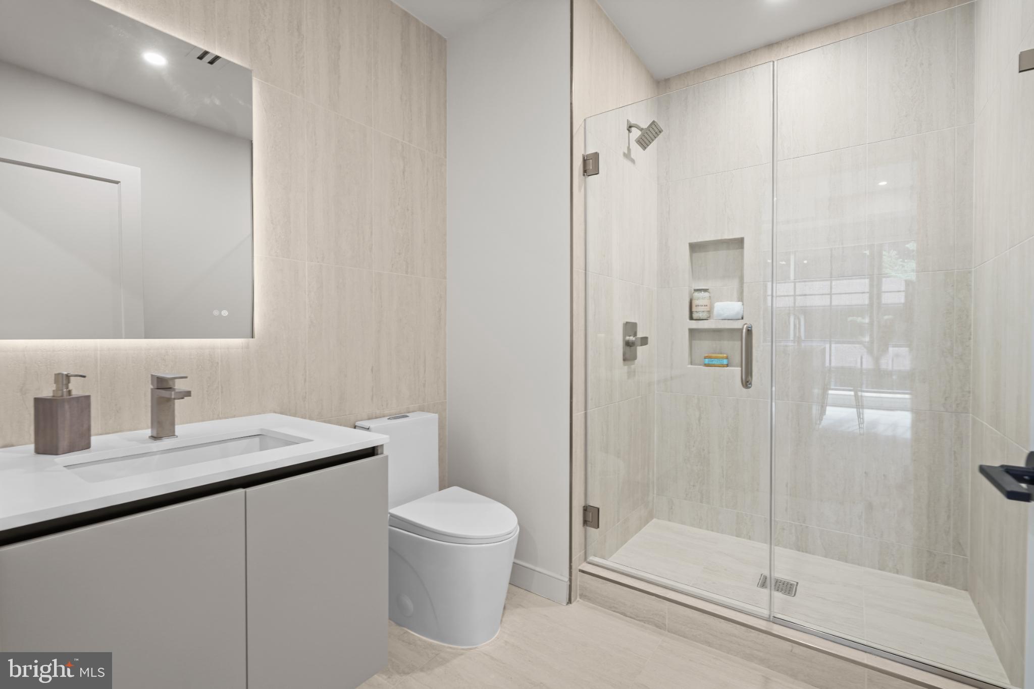 2121 Ward Place Northwest, Unit 304 Washington, DC 20037 - Photo 13 of 20 a bathroom with a granite countertop sink a toilet and shower