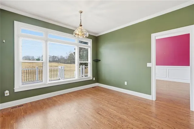 a kitchen with granite countertop white cabinets and a wooden floors