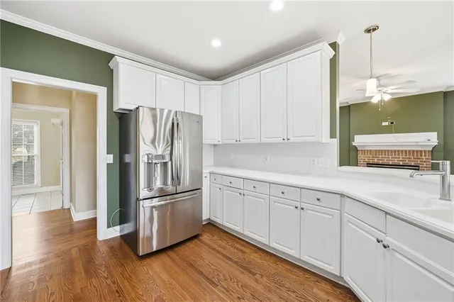 a kitchen with stainless steel appliances white cabinets and wooden floors
