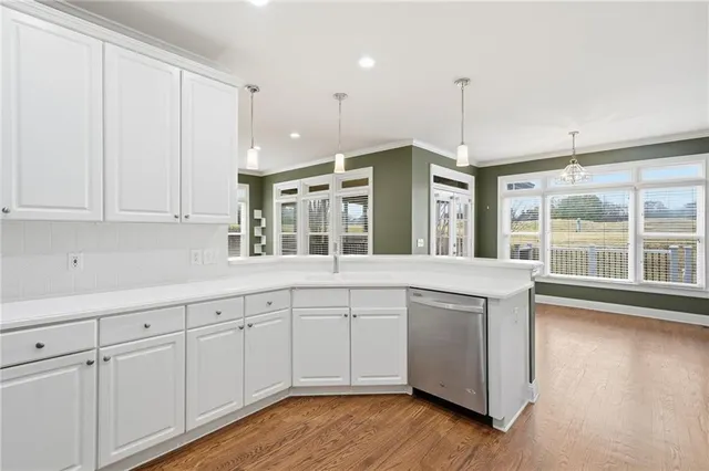 a view of an empty room with wooden floor fireplace and a window