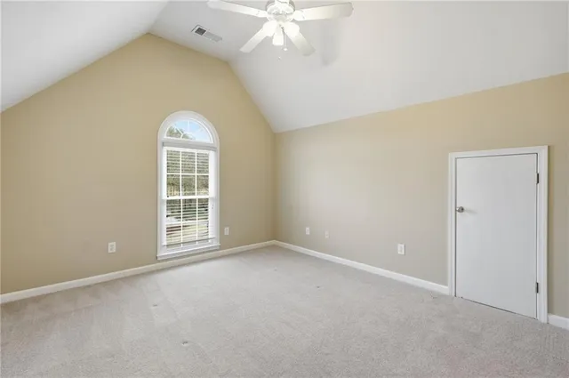 an empty room with a window and ceiling fan