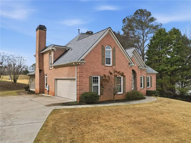 a front view of a house with a yard and trees