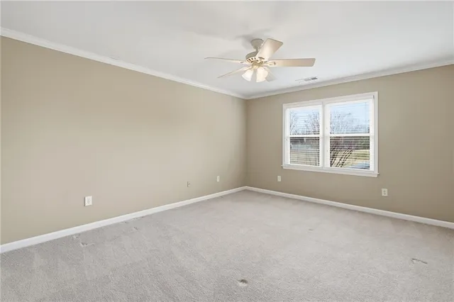 a view of an empty room with wooden floor and windows