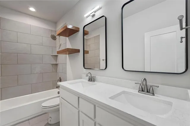 a bathroom with a granite countertop sink a toilet and a mirror
