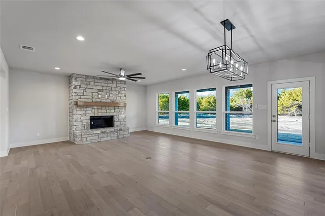 a view of empty room with wooden floor and fireplace