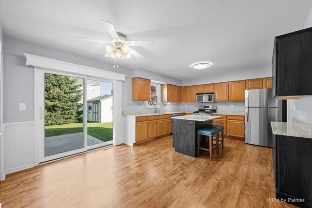 a kitchen with kitchen island granite countertop a sink cabinets and stainless steel appliances