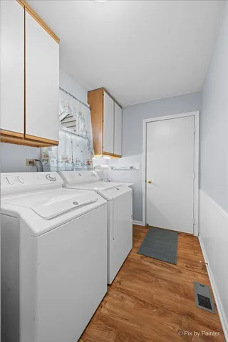 a utility room with cabinets washer and dryer