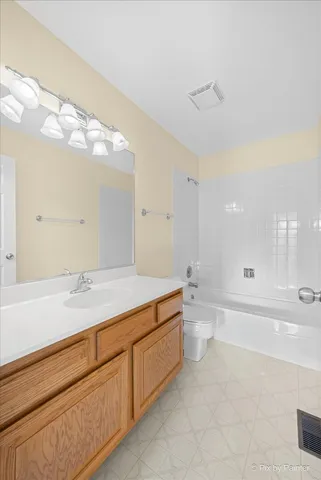 a spacious bathroom with a granite countertop sink a toilet and a large mirror