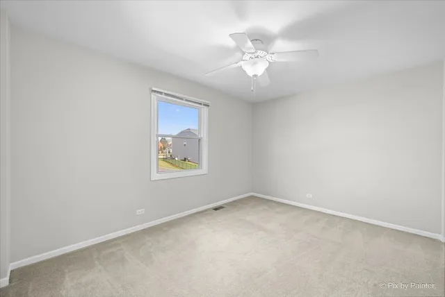 an empty room with a chandelier fan