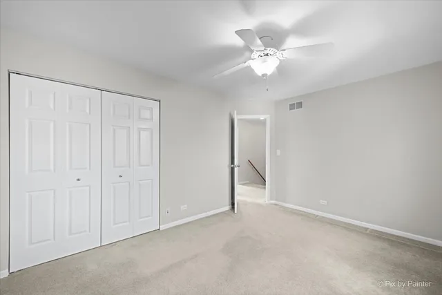 a view of an empty room with a chandelier fan