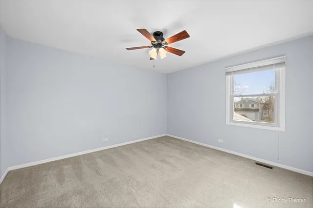 an empty room with window and ceiling fan