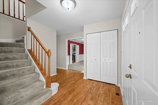 a view of a hallway with wooden floor and staircase