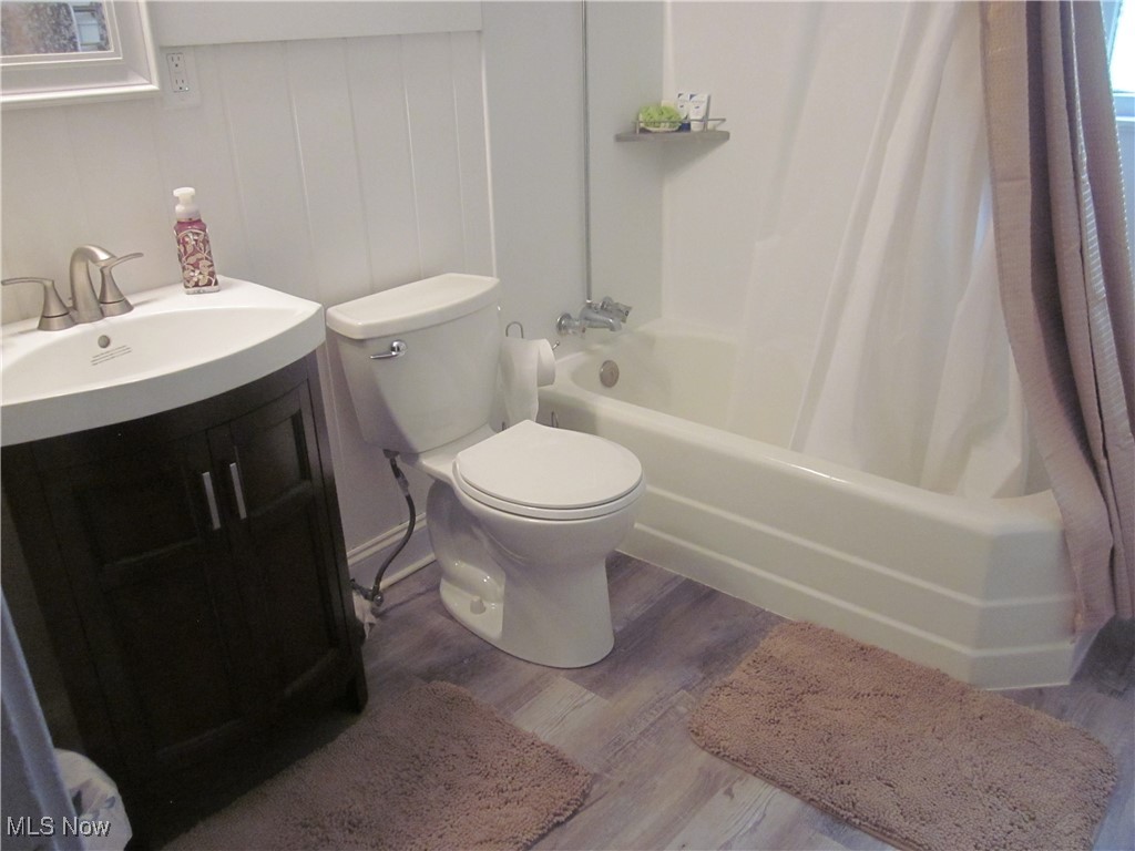 10035 Baltic Road Cleveland, OH 44102 - Photo 28 of 41 Full bathroom with toilet, vanity, wood-type flooring, and shower / bathtub combination with curtain