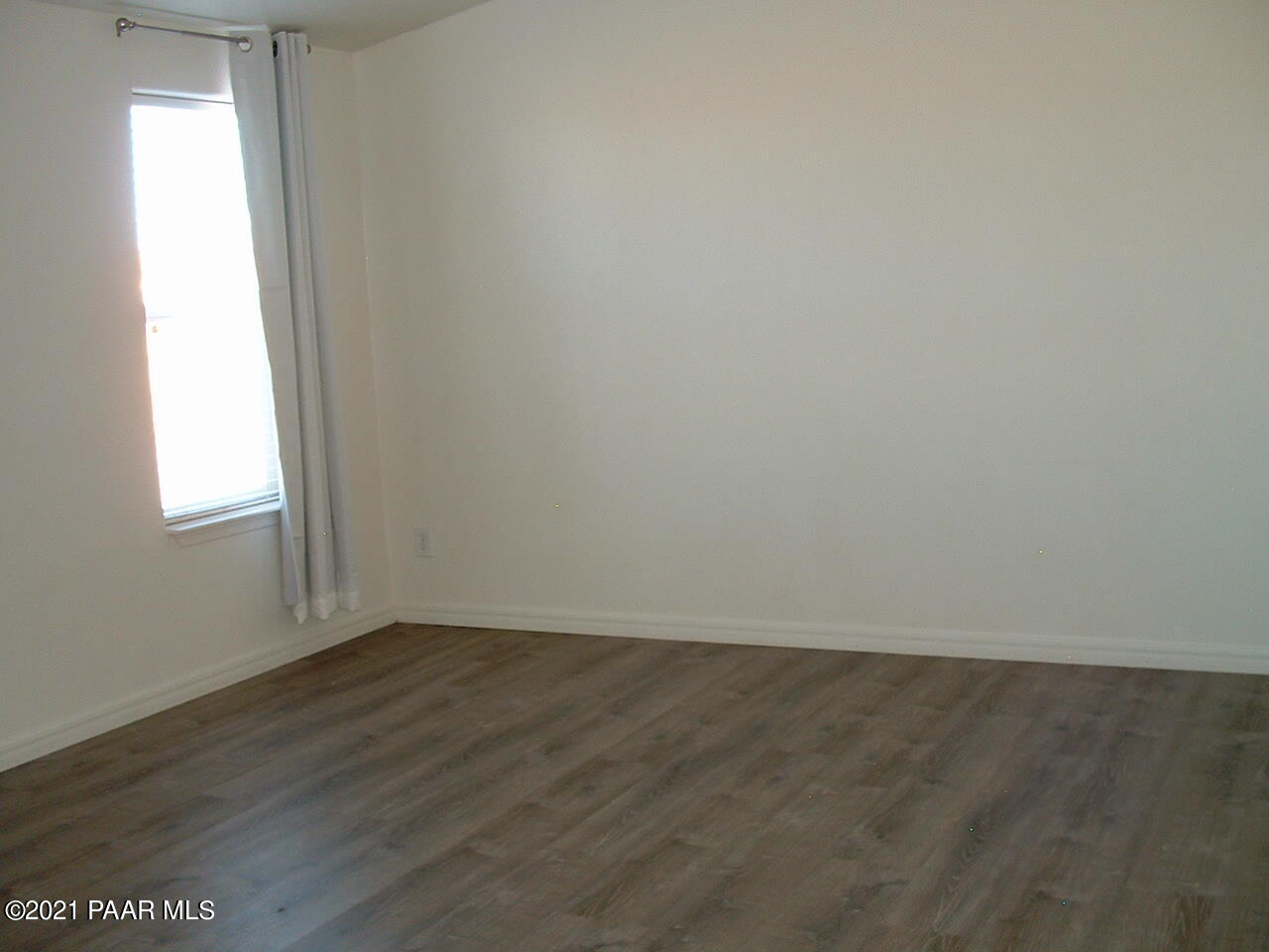 25 West Antelope Run Road Paulden, AZ 86334 - Photo 23 of 27 an empty room with wooden floor and windows