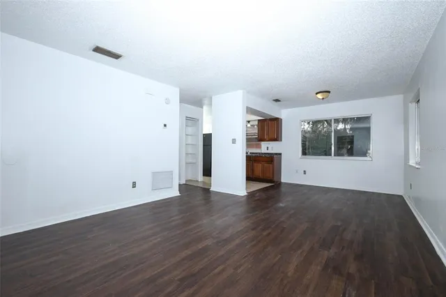 a view of empty room with wooden floor and fireplace