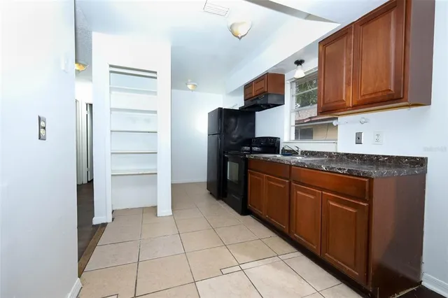 a kitchen with stainless steel appliances granite countertop a refrigerator and a stove top oven