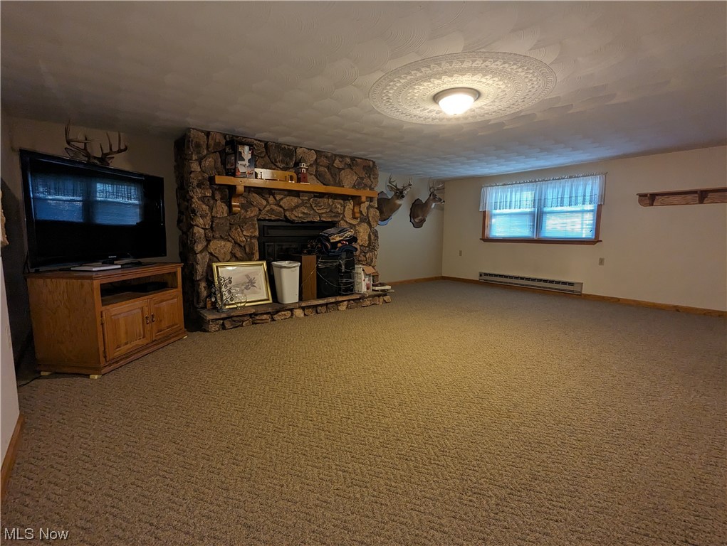 53154 Key Bellaire Road Bellaire, OH 43906 - Photo 23 of 43 Unfurnished living room with a textured ceiling, light carpet, baseboard heating, and a fireplace