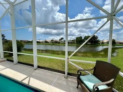 a view of a chair and tables in the patio next to a yard