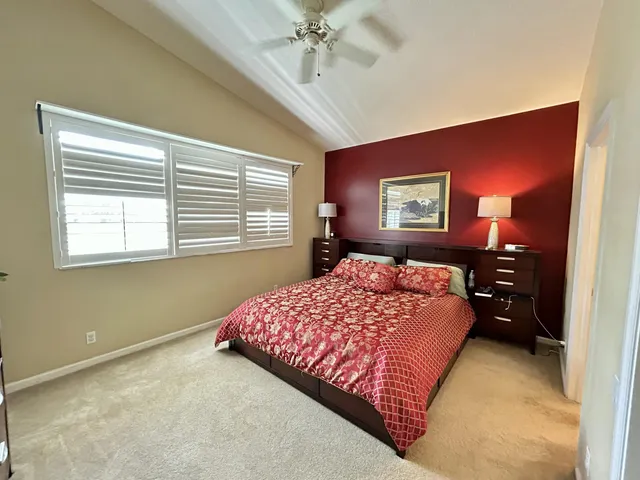 a bedroom with a bed and a dresser next to a window