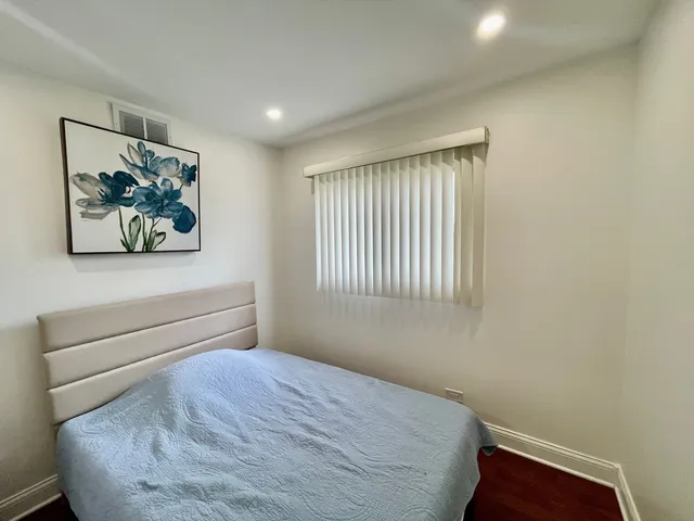 a bedroom with a bed and a painting on the wall