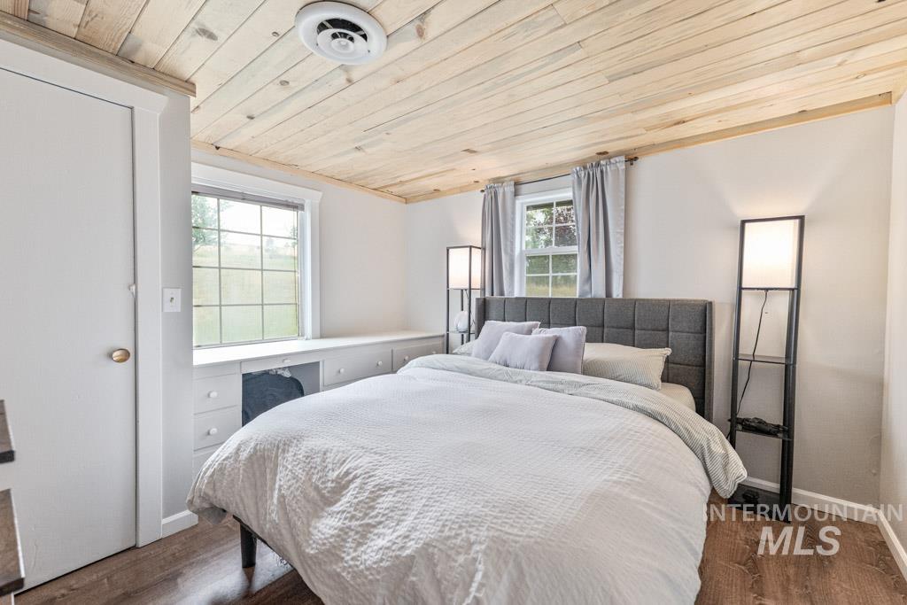 259 Highway 12 Pomeroy, WA 99347 - Photo 23 of 45 Bedroom featuring wood-finish flooring, a paneled wood ceiling, two windows, built-in cabinetry, and a white interior door