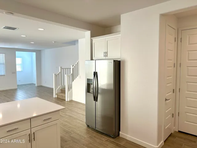 a kitchen with stainless steel appliances a refrigerator and wooden floor