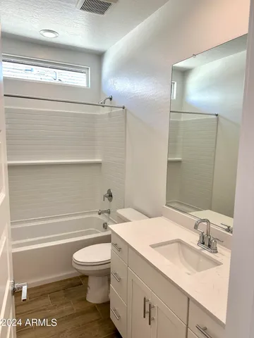 a bathroom with a granite countertop toilet a sink and a mirror
