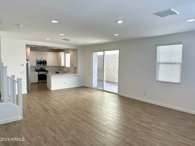 an open kitchen with white cabinets and wooden floor