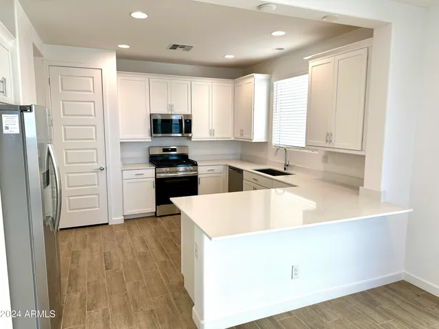 a kitchen with a sink a stove a refrigerator and a microwave