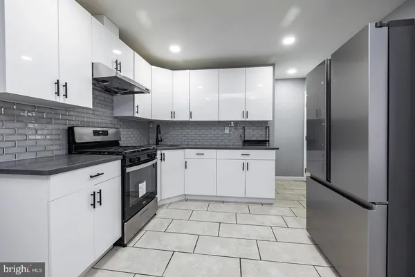a kitchen with a sink a refrigerator and cabinets
