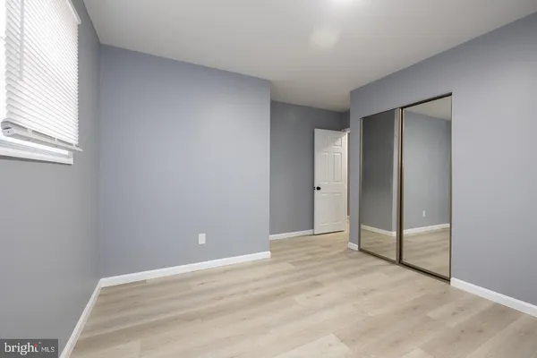 an empty room with windows and closet