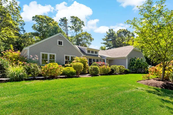 a front view of a house with a garden and yard