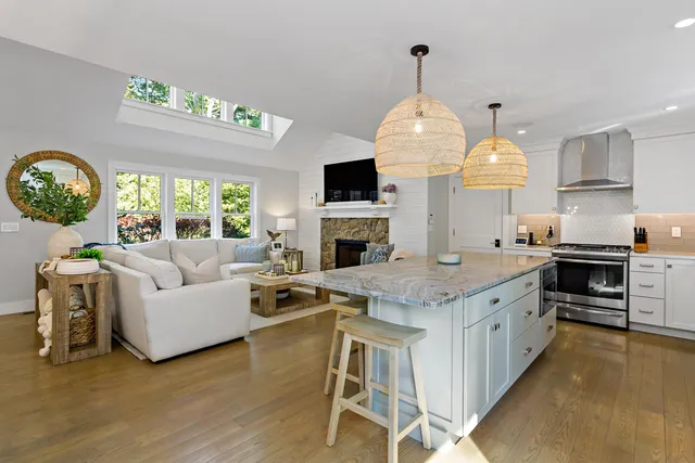 a living room with fireplace furniture and a large window