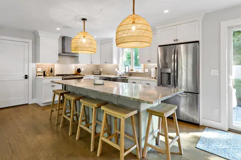 a kitchen with stainless steel appliances granite countertop a sink a stove and a refrigerator